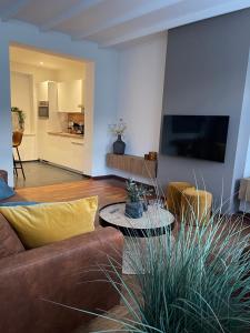 sala de estar con sofá marrón y mesa en Vakantie appartement Sunndays, en Valkenburg