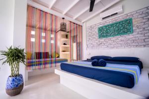 Your Dream Bungalow - Mirissa في ميريسا: غرفة نوم بسرير ازرق وجدار من الطوب