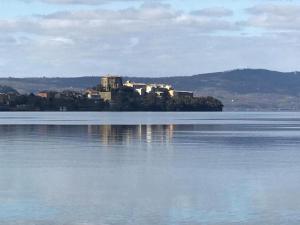 a castle on an island in the middle of a body of water at Casa della zia rosa in Valentano +3 photos
