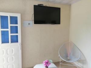 a room with a fan and a television on the wall at Hostal Fisterra in Moniquirá