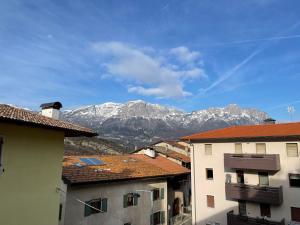a view of snowy mountains from the roofs of buildings at Casa Vacanza Revolta in Trento