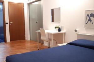 1 dormitorio con cama, escritorio y mesa en B&B accogliente a due passi dal metrò di Milano - Casa Adriana, en Cologno Monzese