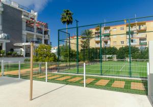una pista de tenis detrás de una valla en una ciudad en Apartamento Victoria Playa III con una gran terraza, en Denia