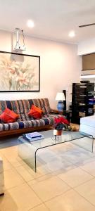 ein Wohnzimmer mit einem Sofa und einem Glastisch in der Unterkunft La Maison BLEUE in Cancún