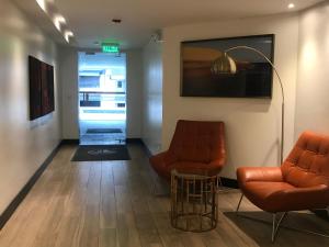 una sala de espera con 2 sillas y una mesa en Naturalhome Apartment Edificio Italia, en Quito