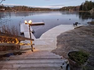 Sjöställe Gudö في Vendelsö: مرسى على بحيرة مع أضواء عليها