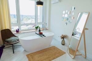 uma casa de banho com uma banheira, uma cadeira e um espelho. em Апартаменти з неймовірною ванною em Kiev