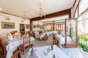 un comedor con mesas y sillas blancas en Hotel El Guía, en Sóller