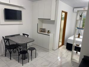 a living room with a table and chairs and a bed at Residencial Campeche 1 in Florianópolis