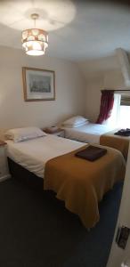 a hotel room with two beds and a chandelier at The Stables at The George Of Wilby in Wellingborough