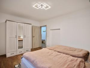 a white bedroom with a bed and a cabinet at Gäste- und Ferienwohnung in der Sportstadt Riesa in Riesa