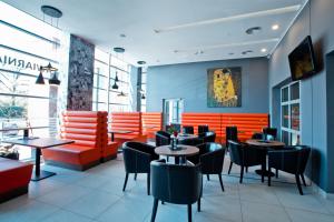 een restaurant met oranje en zwarte tafels en stoelen bij Hotel Europa in Lubin
