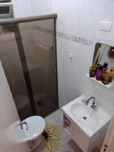 ein Badezimmer mit Dusche, Toilette und Waschbecken in der Unterkunft Casa de frente para o mar, pé na areia. in Praia Grande