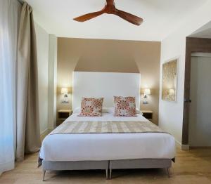 Un dormitorio con una cama con ventilador de techo. en Añoreta Suites, en Rincón de la Victoria