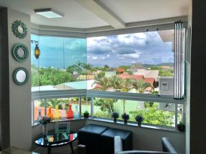 sala de estar con ventana grande con vistas en Lindo apartamento, com excelente localização, em Jurerê!, en Florianópolis
