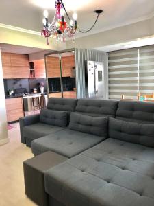 sala de estar con sofá y lámpara de araña en Lindo apartamento, com excelente localização, em Jurerê!, en Florianópolis