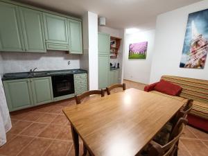 een keuken met een houten tafel en een bank bij Maison Gregory in Prada