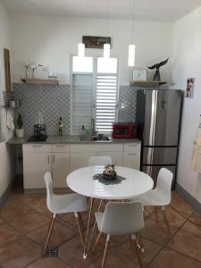 a kitchen with a table and chairs and a refrigerator at One bedroom Apt 30 steps from prime beach generator parking included in San Juan