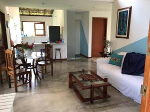 ein Wohnzimmer mit einem weißen Sofa und einem Tisch in der Unterkunft Casa paradise perto da praia Guarajuba - BA in Camassari