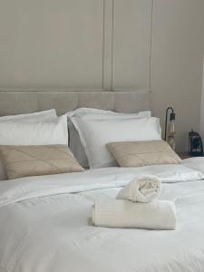 a white bed with a towel on top of it at Emanuel Suite in Eilat