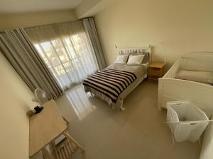 a small bedroom with a bed and a window at 1 Bedroom Hideaway On The Beach in Ras al Khaimah