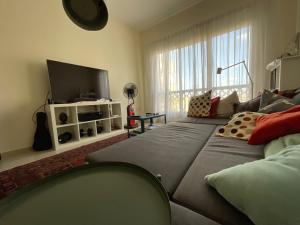 a living room with a large bed and a television at 1 Bedroom Hideaway On The Beach in Ras al Khaimah