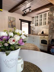 un vase de fleurs assis sur une table dans une cuisine dans l'établissement Rubikiai LUX Duplex Apartamentai, à Anykščiai