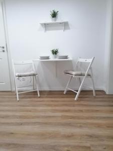 una mesa y sillas blancas en una habitación blanca en Nordunterkunft, en Neumünster