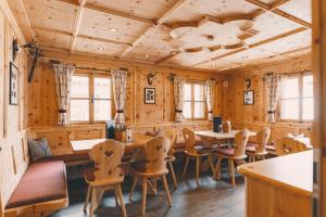 a dining room with wooden walls and tables and chairs at Reitlehenalm in Altenmarkt im Pongau