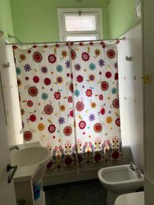 a bathroom with a shower curtain with flowers on it at Corazón de Recoleta in Buenos Aires