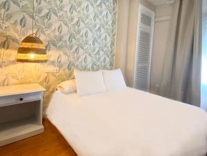 a bedroom with a white bed and a wall at Hotel Plaza Mayor in Ocaña