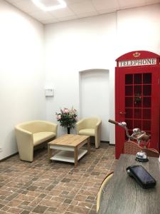 a waiting room with a red telephone booth and a table at Hotel Rover in Lviv +69 photos