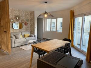 a living room with a table and a couch at Sunset centre Merlimont Plage in Merlimont