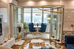 Luxury Apartment Karic FREE parking في توزلا: غرفة معيشة مع طاولة وكراسي أمام نافذة
