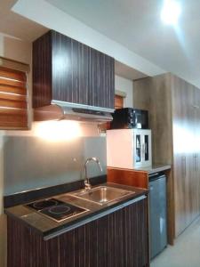 a kitchen with a sink and a microwave at Persimmon Studios - Studio Unit- 16th Floor - 1641 in Cebu City