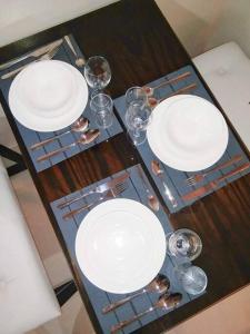 una mesa de madera con placas blancas y gafas. en Persimmon Studios - Studio Unit- 16th Floor - 1641 en Cebu City