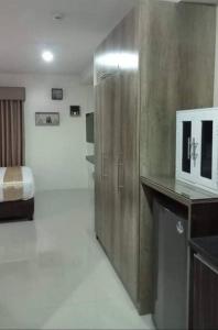 a bedroom with a bed and a wooden cabinet at Persimmon Studios - Studio Unit- 16th Floor - 1641 in Cebu City