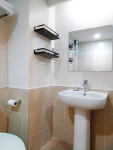 a bathroom with a sink and a toilet and a mirror at Persimmon Studios - Studio Unit- 16th Floor - 1641 in Cebu City