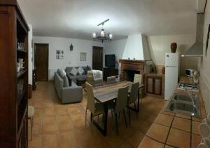 a kitchen and living room with a table and chairs at Cortijo Mazarrón in Güéjar-Sierra