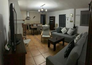 a living room with a couch and a dining room at Cortijo Mazarrón in Güéjar-Sierra