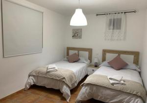 a bedroom with two beds with towels on them at Cortijo Mazarrón in Güéjar-Sierra