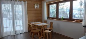 a dining room with a table and some windows at NowiNowe Domki in Dzianisz +21 photos