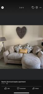 a picture of a couch with a heart on the wall at 2 Bedroom duplex apartment in Bawtry