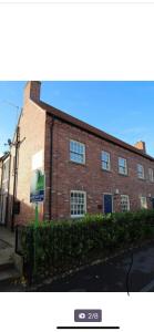 a brick building with a sign in front of it at 2 Bedroom duplex apartment in Bawtry