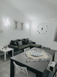 a living room with a couch and a table and a clock at Villa Hippodrom-INDEPENDENT VILLA WITH POOL in Syracuse