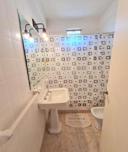 bagno con lavandino, specchio e servizi igienici di Florida Estación a Florida