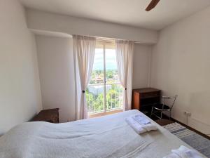 a bedroom with a bed and a large window at Florida Estación in Florida