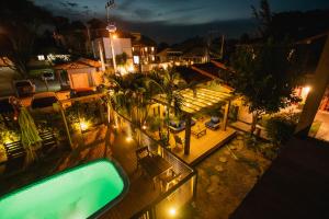 an overhead view of a house with a swimming pool at night at Pousada Cacau in Praia do Rosa