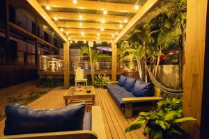 a patio with blue couches and plants on a building at Pousada Cacau in Praia do Rosa +48 photos