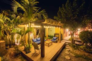 a deck with chairs and a gazebo at night at Pousada Cacau in Praia do Rosa